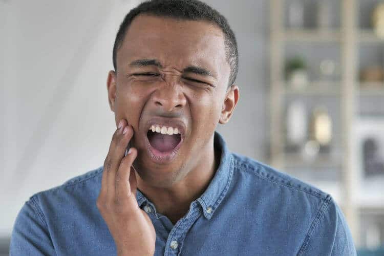 tooth infections of all kinds man holding jaw